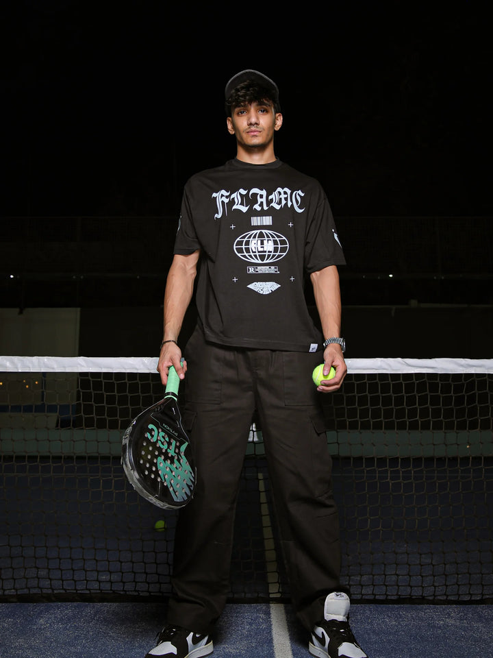 Person holding a paddle and ball on a tennis court at night