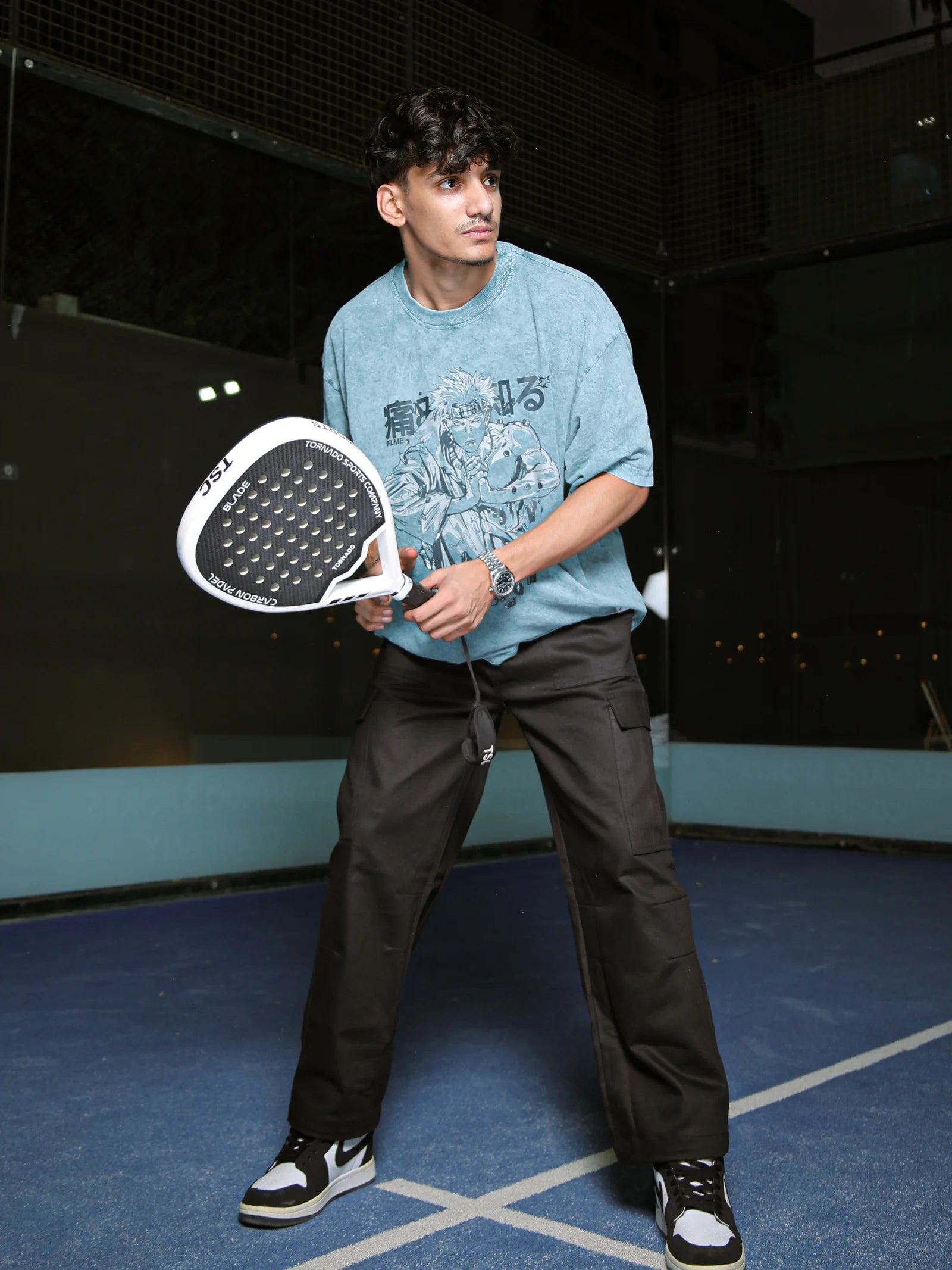 Person holding a paddle on a tennis court